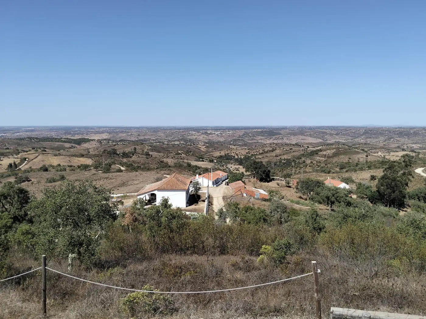 Vista panorâmica do cume da Boavista sobre a planície alentejana e um monte caiado