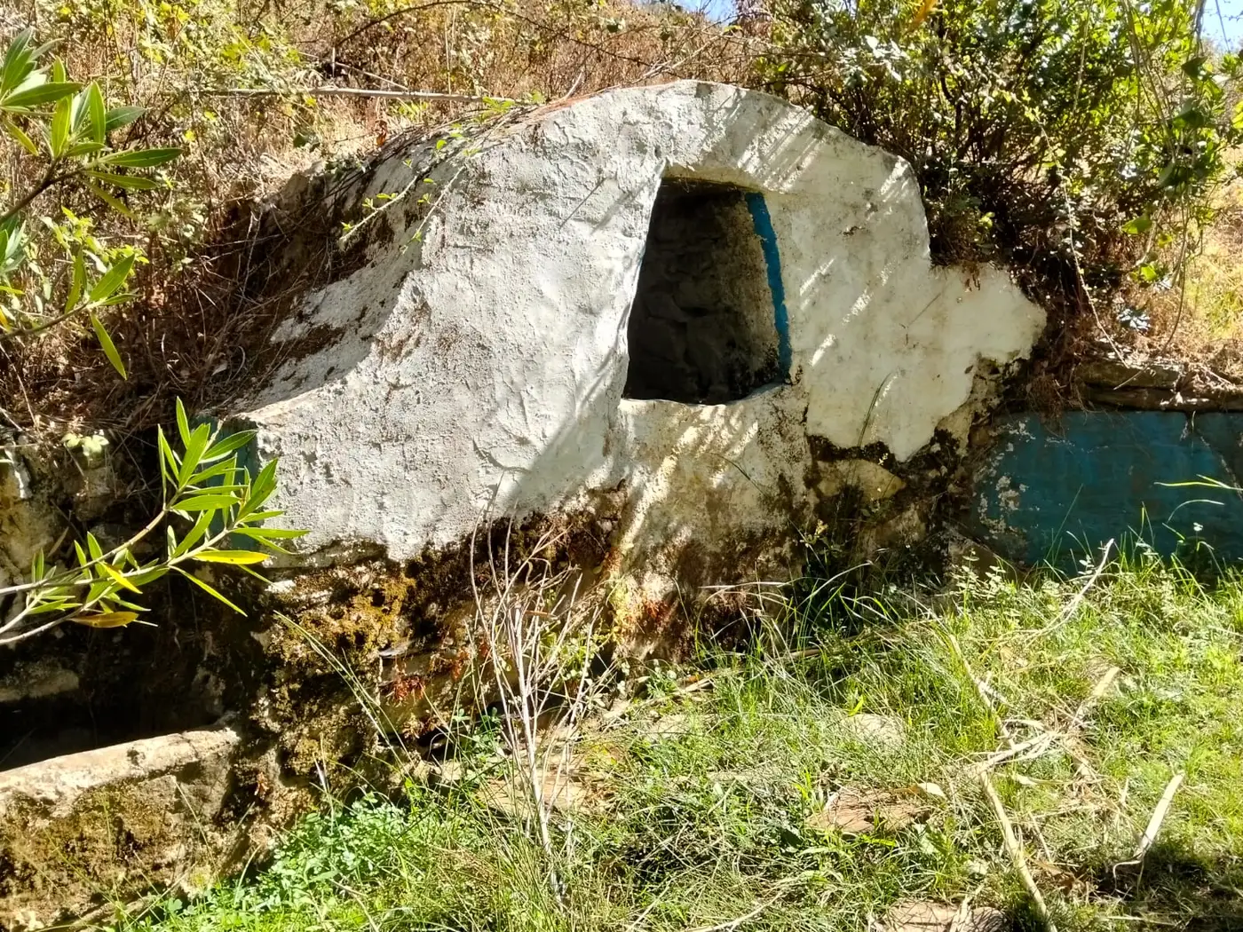 Fonte tradicional abobadada e caiada junto à ribeira, com tanque ao lado